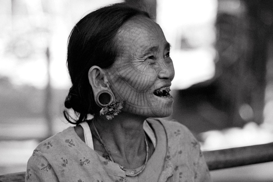 Pan Paung village, Rakhine State 2009: Tattooed woman of unidentified Chin ethnic group along the Lemro River. The tradition of facial tattooing is dying out; younger women do not want to deal with the pain or go against current standards of beauty. Traditional reasons vary slightly, from the Chin women being so beautiful that the menfolk tattooed their faces to disguise their beauty from marauding Burmese, to mothers tattooing their daughters in fear of the King taking them as concubines.

<br><br>This woman was the oldest remaining tattooed lady at age 70, while the youngest was 60. Sharp as a tack, this one; when asked if the tattooing hurt, she replied that it actually hurt twice...because she had to pay to have it done.
