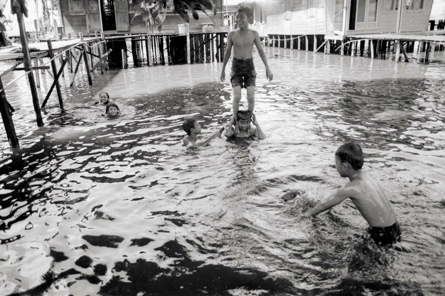 Negara, Kalimantan, Indonesia 2010: a village built over water. Children dive off the piers leading out of every home to play in the water or bathe.